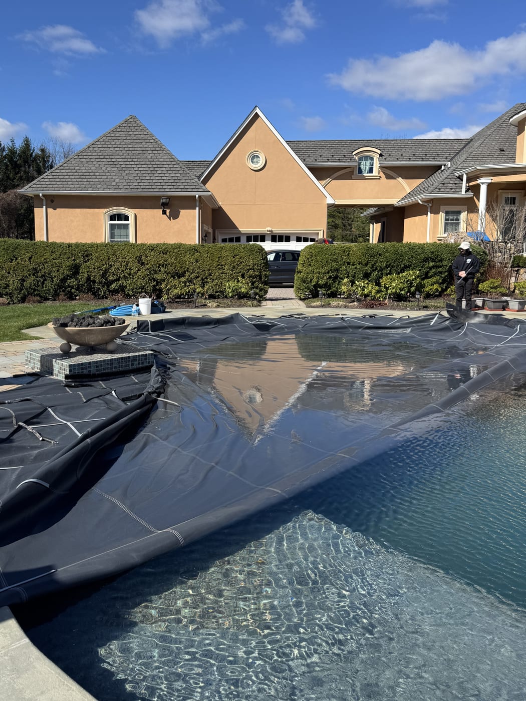 TrueBlue tech pulling the safety cover off a Hunterdon County pool during opening