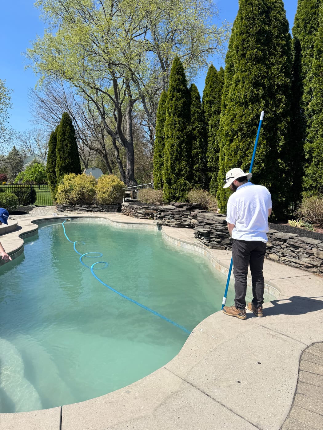 TrueBlue tech vacuuming a clean residential pool